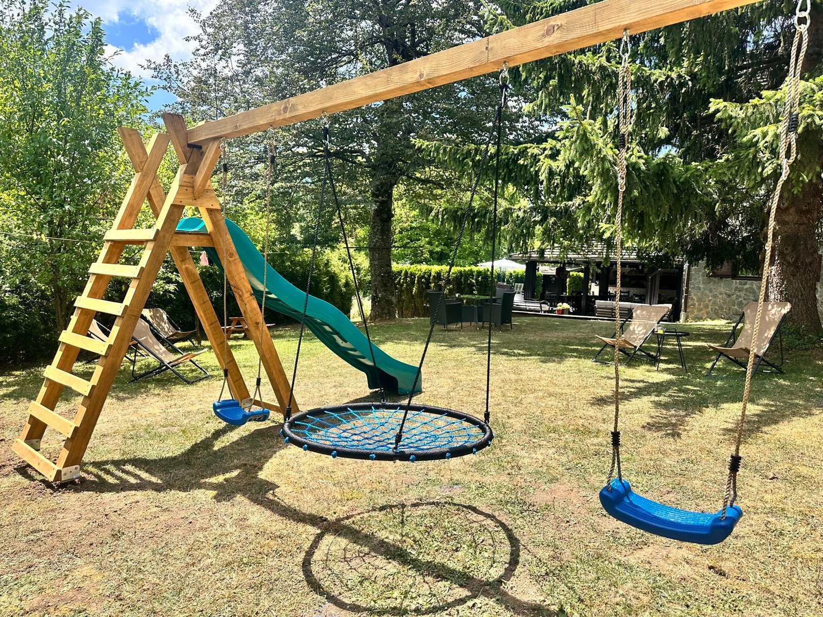Children's play park with swings and slide in the Villa Mukinja garden